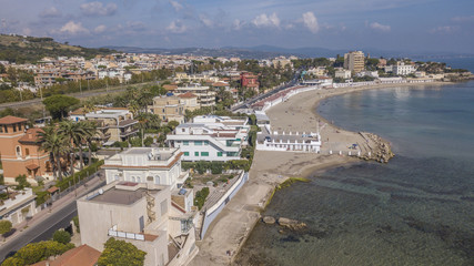 Vista aerea della costa presso il comune di Santa Marinella, vicino Roma, in Italia. In spiaggia non ci sono ombrelloni e poche persone fanno il bagno in mare.