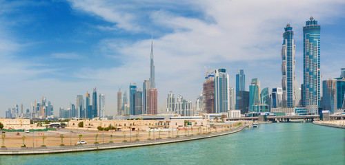 Dubai - The skyscrapers over and the promenade of new Canal and Burj Khalifa in the background.