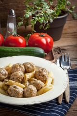 Pork meatballs with dill sauce and pasta. Selective focus.