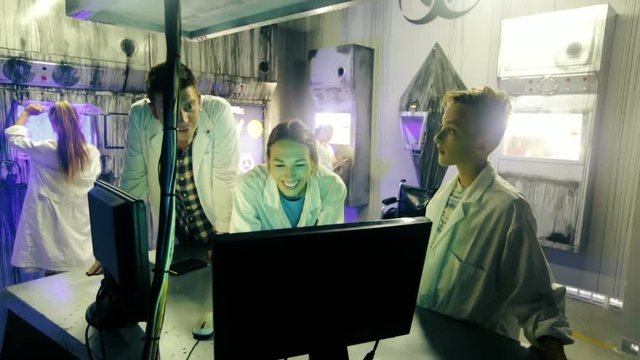 Parents with their children are visiting the escape room stylized under laboratory.
