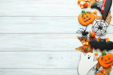 Halloween gingerbread cookies with candies on white wooden table
