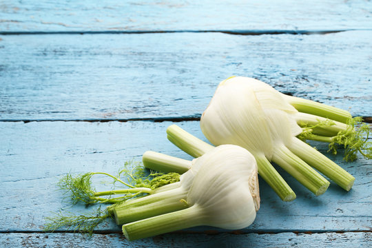 Ripe fennel bulbs on blue wooden table