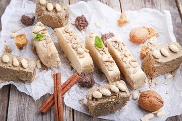 Tasty slices of halva with walnut and cinnamon on grey wooden table
