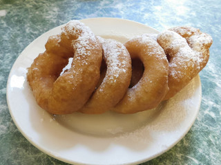 Doughnuts, sprinkled with powdered sugar on the plate