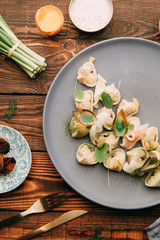 dumplings with potatoes, cheese, berries, compositions for the menu of the restaurant, decorated with greens and sauce