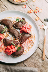 dumplings with potatoes, cheese, berries, compositions for the menu of the restaurant, decorated with greens and sauce