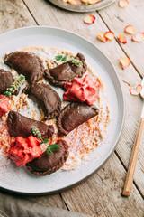dumplings with potatoes, cheese, berries, compositions for the menu of the restaurant, decorated with greens and sauce