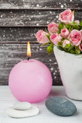 Fototapeta na wymiar Pink roses in concrete pot with candle