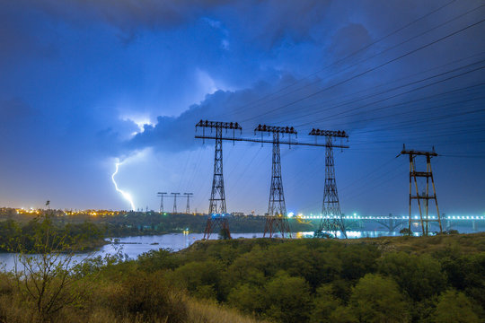 Lightning over the power line pylon towers at night - Powered by Adobe