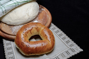 bagel and dough on a napkinon a black background close up