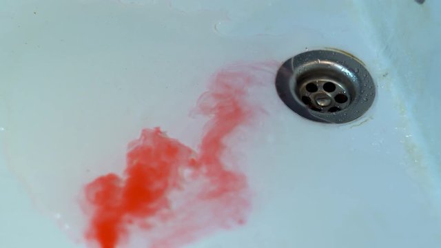 A red liquid similar to blood flows down the white sink into the drain. Blue eyes fall to the outfall. Scary jokes for Halloween.
