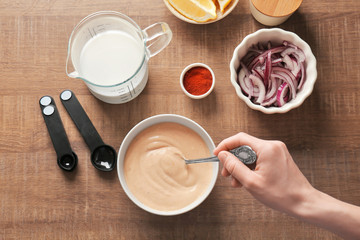 Woman preparing sauce for fish taco in kitchen