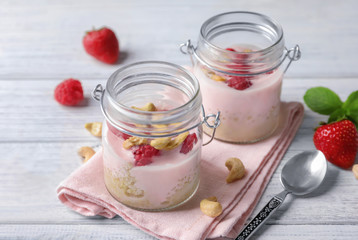 Glass jars with tasty quinoa on wooden table