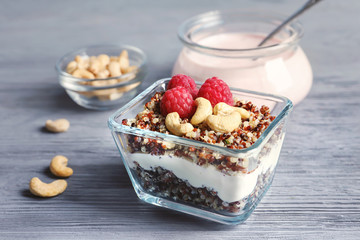 Glass bowl with tasty quinoa on wooden table