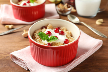 Ramekin with tasty quinoa on wooden table