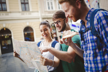 Young happy tourists sightseeing in city