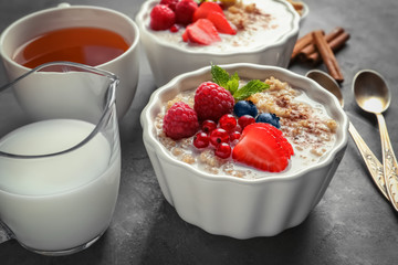 Tasty quinoa with berries in bowl on table