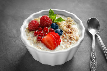 Tasty quinoa with berries in bowl on table