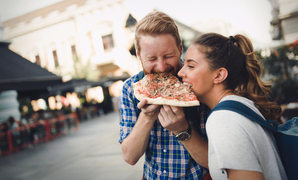 Fototapeta Happy students eating pizza on street