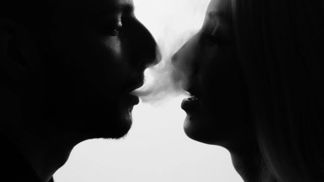 Man gives smoke kiss to woman. Vape culture. Seamless loop. Black and white