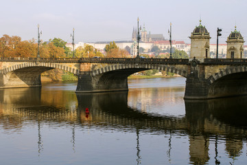 Fototapeta premium View of the Prague Castle and the bridge on the Vltava River in a misty autumn morning. Prague. Czech Republic .