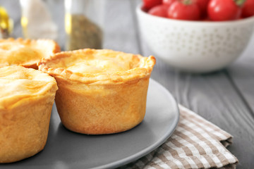 Plate with delicious meat mini pies on table, closeup