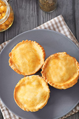 Plate with delicious meat mini pies on table