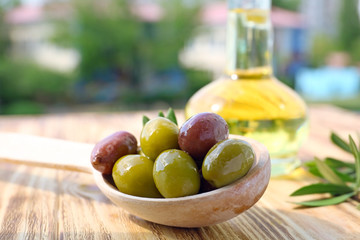 Spoon with canned olives on table