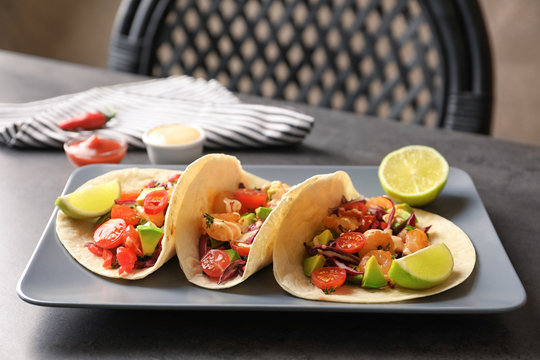 Plate with delicious shrimp tacos on kitchen table