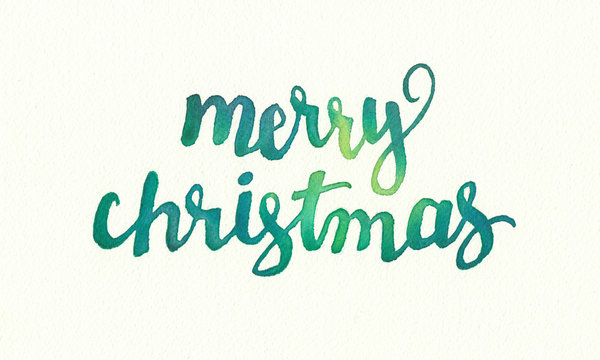 Merry Christmas greeting in hand painted watercolor design, flowing fancy lettering in blue green colors on water color paper texture, festive holiday saying in beautiful handwriting