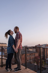 Date night on roof. Couple tender relationships. Happy young people outdoors, strong romantic bound, free space, love on top of the world concept
