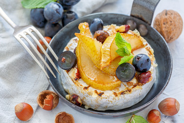 Skillet with baked camembert,caramelized pears and grapes.