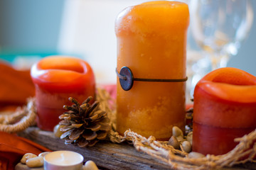 Rustic fall centerpiece with pinecones, orange candles and tealights.