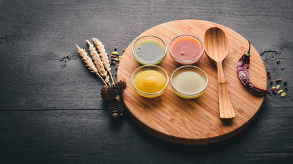 A set of sauces and spices. On a wooden background. Top view. Free space for text.