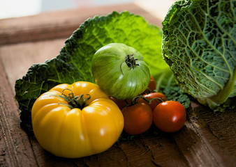 Still life of green, yellow, red tomatoes and cabbage
