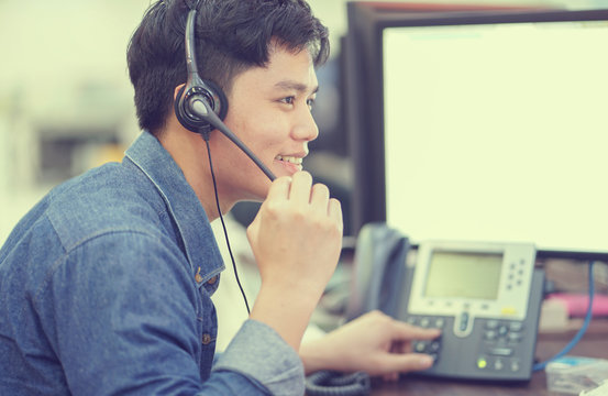 close up asian call center employee man working smiling with service-mind