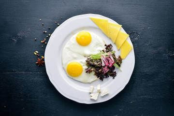 Scrambled eggs with cheese and herbs. On a wooden background. Top view. Free space for text.