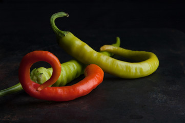 Red and green pepper on black