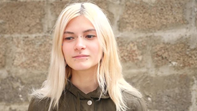 bodimodification, portrait of a girl with face piercings and tunnels in the ears. 4k, slow-motion shooting, copy space