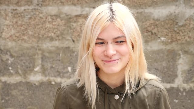 bodimodification, portrait of a girl with face piercings and tunnels in the ears. 4k, slow-motion shooting, copy space