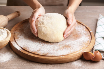 Female chef with dough on kitchen table