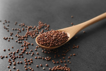 Spoon with quinoa seeds on table