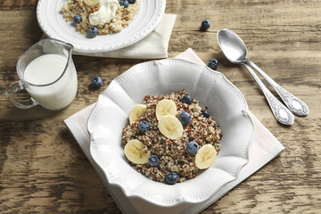 Dessert with quinoa, banana and blueberries on wooden table