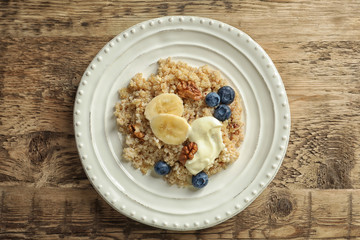 Dessert with quinoa, banana and blueberries on wooden table