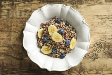 Dessert with quinoa, banana and blueberries on wooden table