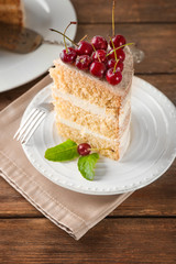 Piece of cake decorated with cherries on plate