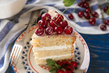 Piece of cake decorated with cherries on plate