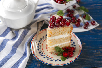 Piece of cake decorated with cherries on plate