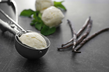 Scoop with vanilla ice cream on grey background