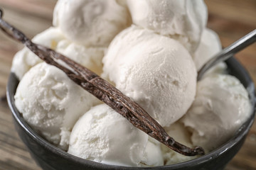 Bowl with yummy vanilla ice cream balls on table, closeup
